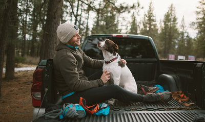 Timothy sits in back of truck with his dog before a run on the trail.