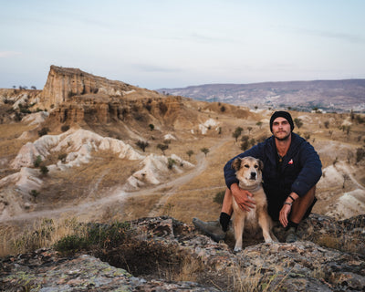 Man and dog sitting in a desert landscape in Kyrgystan