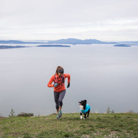 Krissy and her dog PD run up a hill overlooking a big lake